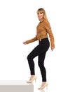 Young Woman In Brown Suede Jacket Is Walking At The Step And Looking At Camera. Side View Royalty Free Stock Photo