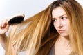 Young woman with brush and tangled hair