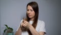 Young woman brushes her hair with a comb. Female is doing and styling her hair.