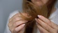 Young woman brushes her hair with a comb. Female is doing and styling her hair.