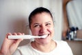 Young woman brushes teeth in bathroom an electric brush