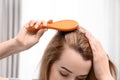 Young woman brushing hair against blurred background Royalty Free Stock Photo