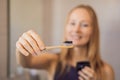 Young woman brushing her teeth with a black tooth paste with active charcoal, and black tooth brush in her bathroom Royalty Free Stock Photo