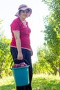 Young woman with bucket of apples in apple orchard Royalty Free Stock Photo