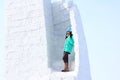 Young woman builds snow castle wall of snow blocks. Winter vacation. Winter and new year holidays