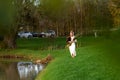 Young woman with a bulrush grass reed walks on the background of green nature Royalty Free Stock Photo