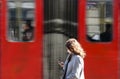 Young woman at bus stop looking at mobile phone