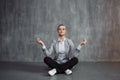 Young woman in business suit sitting in Lotus pose, restore energy, meditate. Health and work Royalty Free Stock Photo