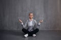 Young woman in business suit sitting in Lotus pose, restore energy, meditate. Health and work Royalty Free Stock Photo