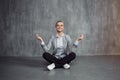 Young woman in business suit sitting in Lotus pose, restore energy, meditate. Health and work Royalty Free Stock Photo