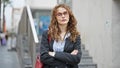 Young woman business worker standing with arms crossed gesture and serious face at street Royalty Free Stock Photo