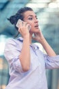 Young woman busy with calling, chatting on the cell phone side view portrait. Royalty Free Stock Photo