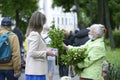 Young woman buying flowers from an old woman flower seller on the street of the city Royalty Free Stock Photo