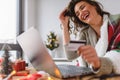 Young woman buying online at home  for winter holidays using laptop computer Royalty Free Stock Photo