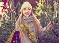 Young woman buying Xmas tree at festive fair