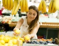 Young woman buys fruit at the market Royalty Free Stock Photo