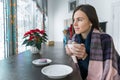 Young woman in cafe with cup of hot drink with warm blanket Royalty Free Stock Photo