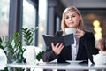 Young woman in cafe reading an ebook and drinking coffee Royalty Free Stock Photo