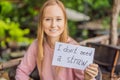 Young woman in a cafe shows a sign - I don`t need a straw. No plastic. Global environmental protection issue Royalty Free Stock Photo