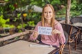 Young woman in a cafe shows a sign - I don't need a straw. No plastic. Global environmental protection issue Royalty Free Stock Photo