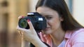 Young woman calibrating camera lens, photo shooting outdoors, photojournalist
