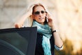 Fashion business woman in sunglasses calling on cell phone by car Royalty Free Stock Photo