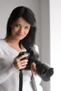 Young woman with camera. Portrait of beautiful young woman holding a camera and looking at you