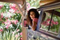 Young woman in a camper van in a beautiful camping with pink flowers