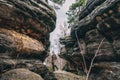 Young woman in canyon, lady hiker standing between big stones or rocks