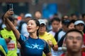 Young woman with a captain america T-Shirt taking a selfie at the Chengdu Marathon