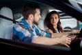 Young woman in the car, male instructor sitting next to her while explaining on the lesson in drive school. Driving test Royalty Free Stock Photo