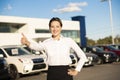 Young woman car rental in front of garage with cars on the background Royalty Free Stock Photo