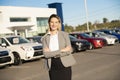 Young woman car rental in front of garage with cars on the background Royalty Free Stock Photo