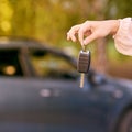Young woman in car. Ride instruction. Automobile loan. Hand with key Royalty Free Stock Photo