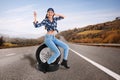 Young woman with car tires on asphalt road Royalty Free Stock Photo