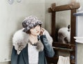 Young woman carrying a fox stole on her shoulders and adjusting her earring Royalty Free Stock Photo