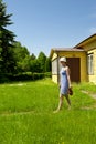 Young woman carrying jug by the summer house