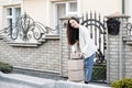 Young woman carrying parcels home, standing with a heap of cardboard boxes. Concept of buying goods online and delivering them Royalty Free Stock Photo