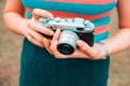 A young woman is carrying a vintage camera outdoor