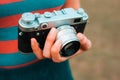 A young woman is carrying a vintage camera outdoor