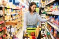 Young woman with the cart shopping in grocery store Royalty Free Stock Photo