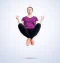 Young woman in casual clothes with her eyes closed is relaxed levitating in the air in the lotus position. Relaxation concept Royalty Free Stock Photo