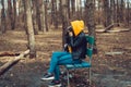 Young woman in casual clothes sitting on bench and photographing on old photo camera in forest. Female resting and Royalty Free Stock Photo