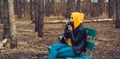 Young woman in casual clothes sitting on bench and photographing on old photo camera in forest. Female resting and Royalty Free Stock Photo