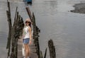 Young woman in casual clothes standing on an old wooden pier and looking at the view River Royalty Free Stock Photo