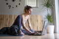 Young woman in casual clothing sitting on a living room floor working and using laptop computer Royalty Free Stock Photo