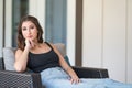 Young woman in a casual leisurely pose on patio chair