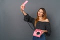 Young woman casual studio on gray with retro telephone trying to make selfies