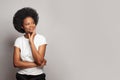 Young woman in casual white t-shirt smiling looking up at copy space against white studio wall banner background Royalty Free Stock Photo