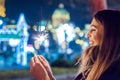 Young woman celebrating an event the New Year is coming. She holding glittering sparkler on.